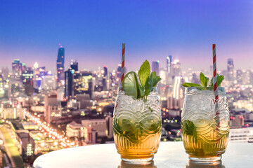 two mojitos in a rooftop bar with a view over Bangkok