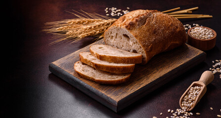 A loaf of brown bread with grains of cereals on a wooden cutting board