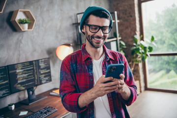 Photo of cheerful positive programmer wear spectacles crating ebank ecard app modern device indoors workplace workshop home