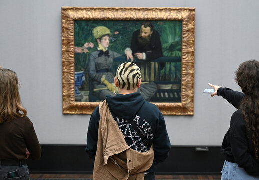 Berlin, Germany - November 03, 2022: People observing "In the Conservatory", 1879 oil painting by Edouard Manet in the Alte Nationalgalerie in Berlin.