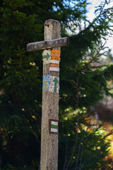 Old concrete pole with markings of mountain trails