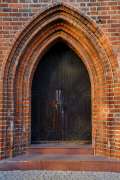 Old, historic wooden doors in a brick castle.