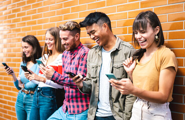 Multicultural friends using smart phones at university college break - Milenial students addicted...