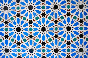 Fototapeta premium Geometric seamless andalusian moroccan islamic arabic star pattern in blue made out of ceramic tiles in Spain Sevilla