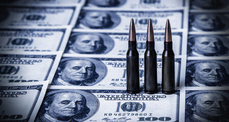 Bullets on money (US Dollars) as symbol of war, terrorism and dirty business. Copy space.