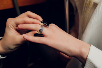 The groom puts a ring on the bride's hand. Newlyweds exchange rings, groom puts the ring on the...