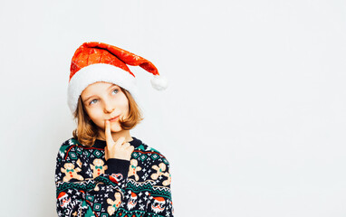 Cute girl in Santa Claus hat thinks about a gift