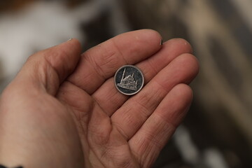 Fototapeta na wymiar Small arab coin in hand