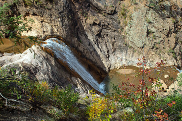 A view of a waterfall from top to bottom in a canyon