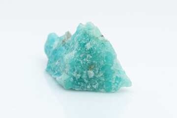 Natural amazonite gemstone isolated on white background. A bluish-green crystal on a white background. A variety of potassium feldspar microcline