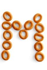 Letter M bagel. Bagels font. Alphabet from set of small dry bagels isolated on white background. ABC symbols.