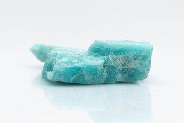 Natural amazonite gemstone isolated on white background. A bluish-green crystal on a white background. A variety of potassium feldspar microcline