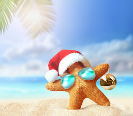 Starfish in Santa Claus hat and christmas ball on a summer beach. Merry Christmas - obrazy, fototapety, plakaty