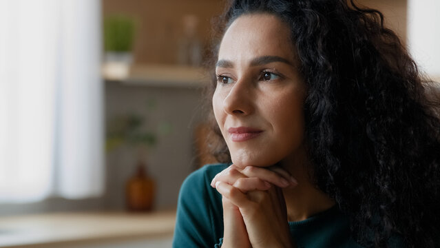 Close Up Head Shot Portrait Peaceful Beautiful Young Woman Relaxing At Home Put Chin On Folded Palms Looking Into Distance Spanish Curly Lady Remembering Positive Moments Dreaming About Carefree Life 