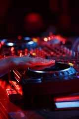Party dj playing music in night club with professional cd turntables. Disc jockey mixing musical...