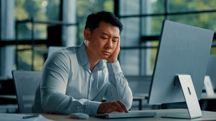 Fototapeta na wymiar Bored lazy asian worker businessman korean japanese man exhausted weary male sit in office asleep tired from boring online work at computer develop business project unwell feeling lack of motivation