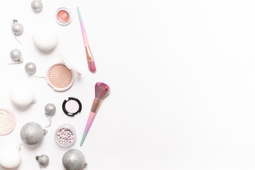 Decorative cosmetic products and shining Christmas decorations on white background with copy space for your design top view. Christmas cosmetic sale and promo banner.