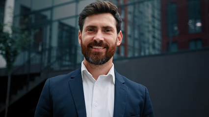 Handsome man caucasian bearded 40s businessman leader boss successful male business owner happy adult millennial guy stand in city outside modern office company posing looking at camera joyful smiling