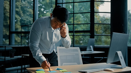 Busy asian businessman korean man working stand at table in modern office talk on phone give...