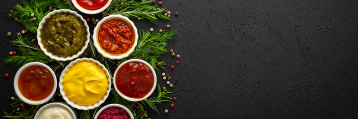 Different types of sauces in bowls with seasonings banner, rosemary and dill, thyme and and peppercorns, top view, copy space
