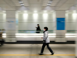 Tokyo,Japan - November 17, 2022: Panning of pedestrians on moving walkway at West Shinjuku, Tokyo, Japan
