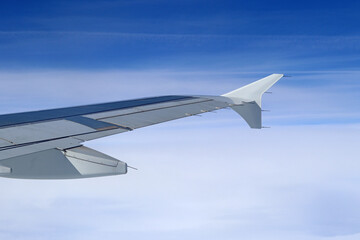Fototapeta na wymiar The wing end of a passenger plane under blue skies