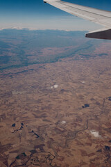 Brown agriculture fields landscape in Spain seen from an airplane window from the sky