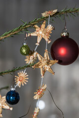 Fototapeta premium Strohstern und Weihnachstkugel am Christbaum