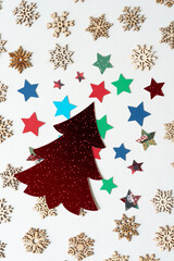 Fototapeta na wymiar holiday tree, paper stars, and wooden snowflake embellishments on blank paper