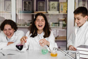 Obraz premium Education. Chemical experiments at a chemistry lesson at school. Children classmates making experiments in the laboratory.