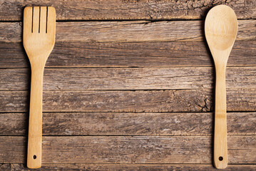 Wooden spoon and fork on old rustic wooden table, copy space.