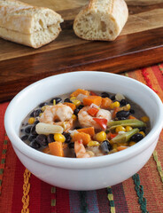 Bean and Shrimp Chowder in White Bowl Against Stripes Vert