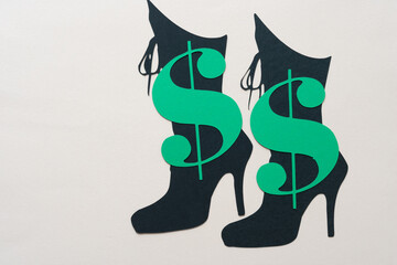 green paper dollar signs and black paper boot shapes or glyph cutouts