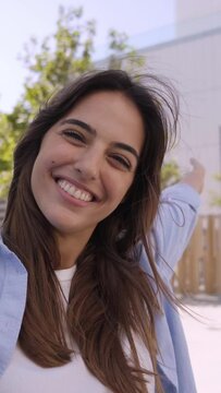 Vertical video portrait Young beautiful woman smiling Taking selfie video university campus. Girl in casual attire. Positive cheerful female student posing outdoors sharing social media Caucasian lady