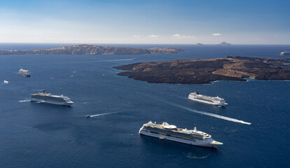 Many luxury cruise ships anchored by island in blue water. Travel, voyage and vacation concept