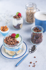 Domowe, zdrowe śniadanie. Naturalny grecki jogurt  z czekoladowym musli, bananami i malinami. - obrazy, fototapety, plakaty