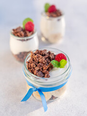 Domowe, zdrowe śniadanie. Naturalny grecki jogurt  z czekoladowym musli, bananami i malinami. - obrazy, fototapety, plakaty