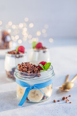 Domowe, zdrowe śniadanie. Naturalny grecki jogurt  z czekoladowym musli, bananami i malinami. © Dorota