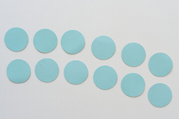 blue cardboard dots on blank paper