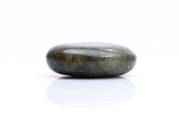 Natural gemstone labradorite isolated on white background. Dark gray labradorite with an inner...