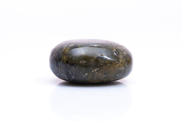 Natural gemstone labradorite isolated on white background. Dark gray labradorite with an inner iridescent glow on a white background