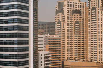 Close-up view from high above on the facades of huge residential high-rises; elevations of dwelling skyscrapers on a bright day