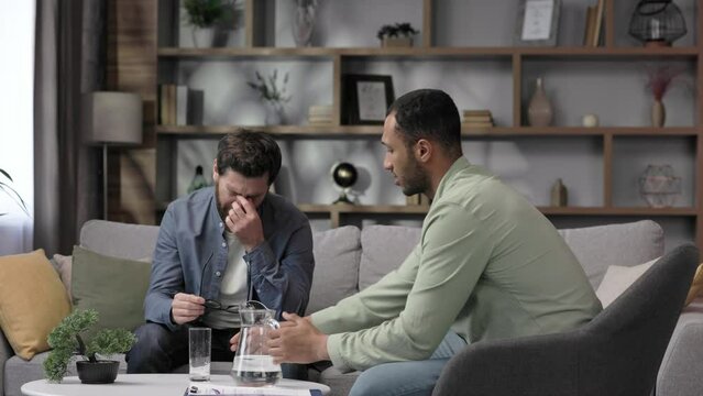 Visit to a psychologist. A man sits on a couch and talks to a psychotherapist. The patient is depressed, apathetic and stressed from problems in his personal life. Help of a psychologist.