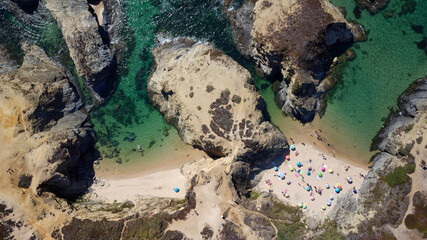 Aerial drone view of busy Beach in Algarve, Portugal during summer holidays. Amazing destinations.  Travel and adventure. Vacations on the seaside.  Exotic traveling. Most visited places. 