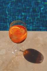 Orange aperol spritz cocktail on summer party standing by the pool. Event celebration concept.