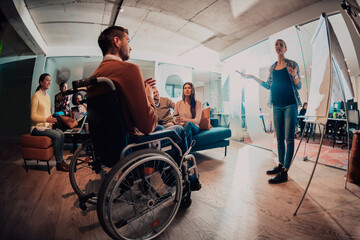  A pregnant businesswoman leads a creative meeting of a diverse business team in a modern coworking