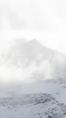Gordijnen Vertical shot of foggy snow-covered mountains in Bormio, Italy © Miscela/Wirestock Creators