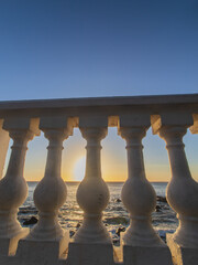 sunset over balustrade  on the beach with a blue sky