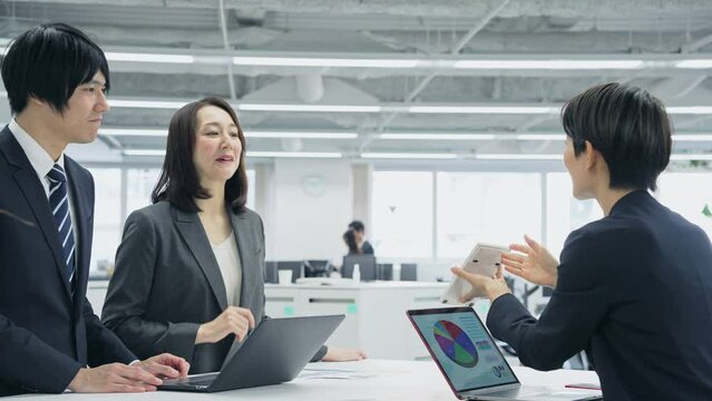 電卓を見せて交渉するビジネスグループ