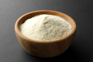 Bowl of agar-agar powder on black background, closeup